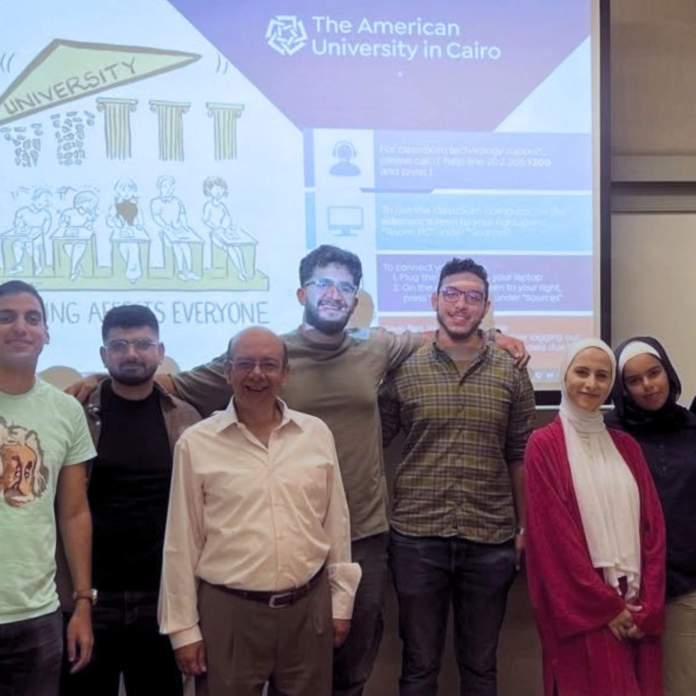 Saja Redwan, writer, posing in front of a projector with her classmates at The American University in Cairo.