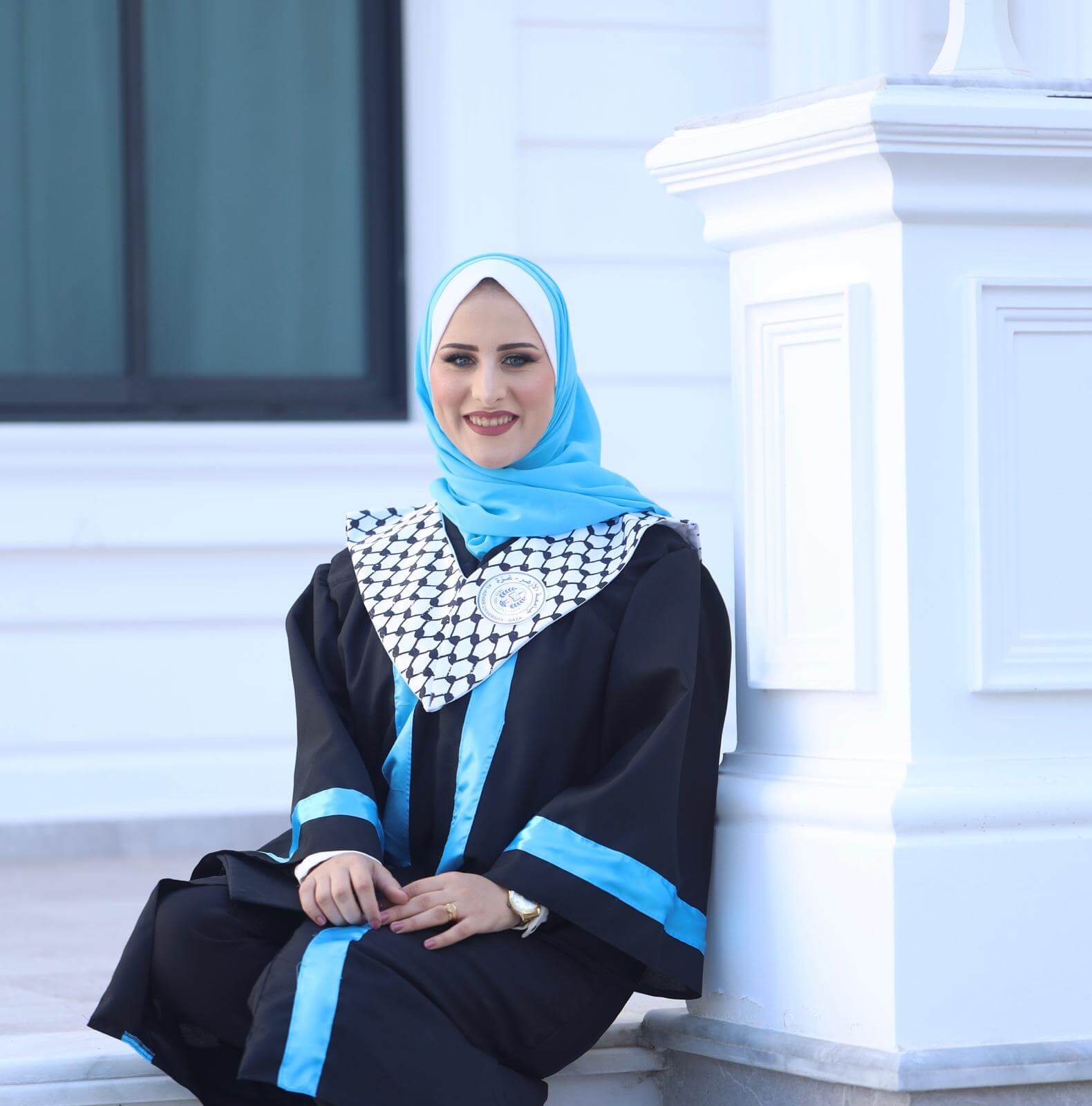Saja Redwan, freelance writer, translator, and marketer, posing for a graduation photo while wearing her cap and gown.